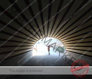 tunnel with woman jumping in the light at it's end