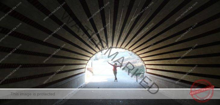 tunnel with woman jumping in the light at it's end